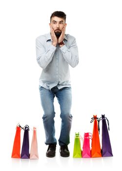 Handsome man with shopping bags is shocked. Christmas and holidays concept