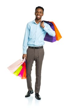 Happy african american man holding shopping bags on white background. Christmas and holidays concept