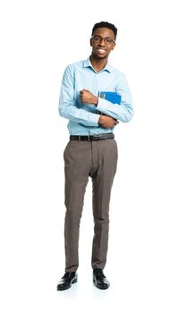 Happy african american college student standing with books in his hands on white background