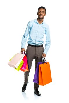 Happy african american man holding shopping bags on white background. Christmas and holidays concept