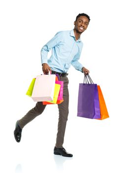 Happy african american man holding shopping bags on white background. Christmas and holidays concept