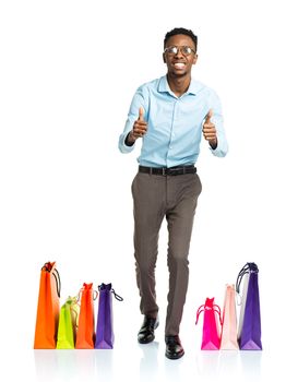 Happy african american man with shopping bags on white background. Christmas and holidays concept