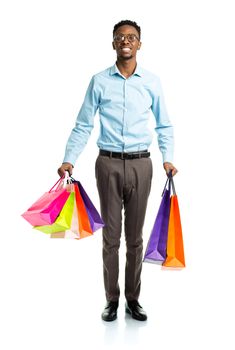 Happy african american man holding shopping bags on white background. Christmas and holidays concept