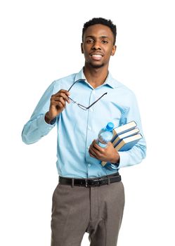 Happy african american college student standing with books and bottle of water in his hands on white background