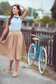 Young beautiful, elegantly dressed woman with bicycle. Beauty, fashion and lifestyle