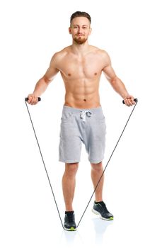 Athletic attractive man jumping on a rope on the white background