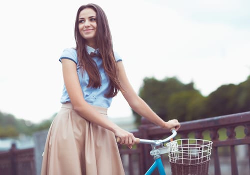 Young beautiful, elegantly dressed woman with bicycle. Beauty, fashion and lifestyle