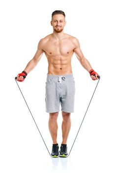 Athletic attractive man jumping on a rope on the white background