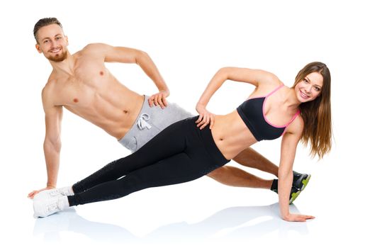 Athletic attractive couple - man and woman doing fitness exercises on the white background