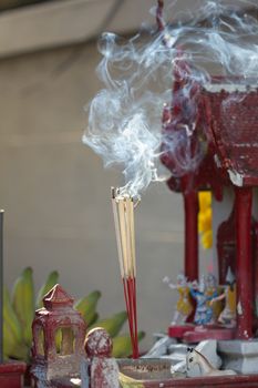 Incense sticks with smoke in front of spirit's house in Thailand