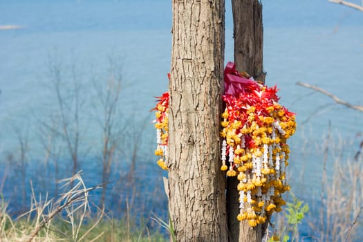 garlands on a trre near dam as background