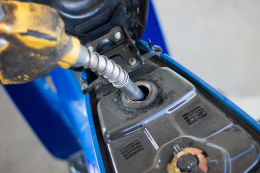 Refueling a motorcycle at a gas station in thailand