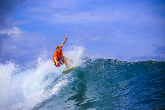 Surfer on Amazing Blue Wave, Bali island.