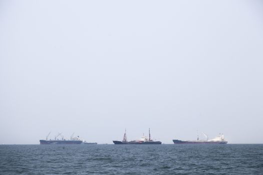 Large cargo ship Boats moored in the sea to make sense compared to the coast.