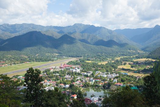 airport is at the foot of the mountain. High mountains near the airport. There is a village in the foothills and airport.