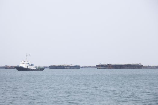 Large cargo ship Boats moored in the sea to make sense compared to the coast.