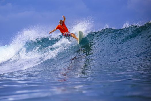 Surfer on Amazing Blue Wave, Bali island.