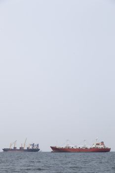 Large cargo ship Boats moored in the sea to make sense compared to the coast.