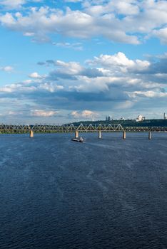 The barge floating in the blue Dnieper waters against the summer Kyiv landscape.