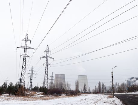 Electricity pylons, power lines and cooling towers of the cogeneration plant near Kyiv (Ukraine) in winter.