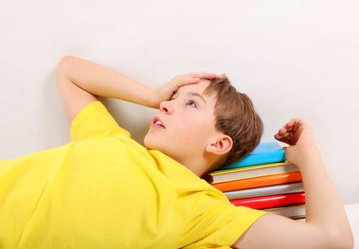 Tired Teenager with a Books at the Home