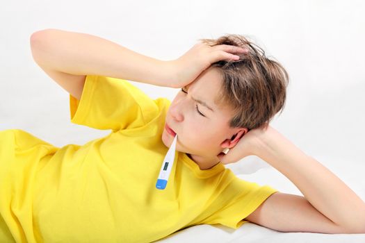 Sick Kid with Thermometer on the Bed