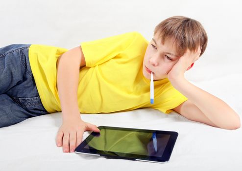 Sick Kid with Tablet Computer and Thermometer on the Bed