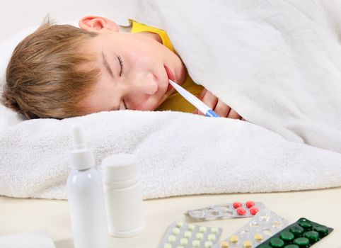 Sick Kid with Thermometer in the Bed