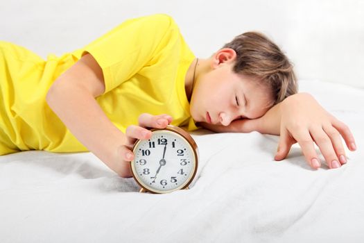 Kid sleep with Alarm Clock on the Bed