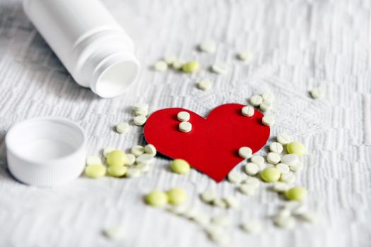 Heart Shape with the Pills on the White Fabric Background