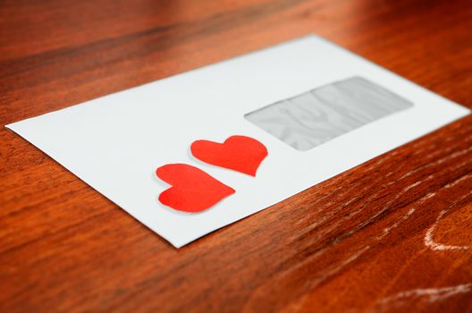 Envelope with a Heart Shapes on the Wooden Background