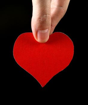 Red Heart Shape in the Hand on the Black Background