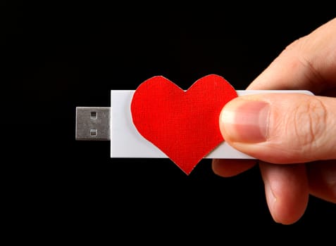 Heart Shape and USB Drive in the Hand on the Black Background