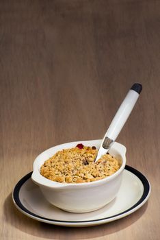 A ceramic dish with freshly baked mixed berry crumble, and a spoon stuck in to the berry crumble.
