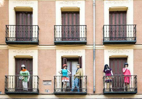 Madrid, Spain - May 6, 2012: Building with dresed manequins on balconies on a street of Madrid, Spain