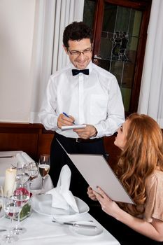 young smiling couple at the restaurant for dinner 