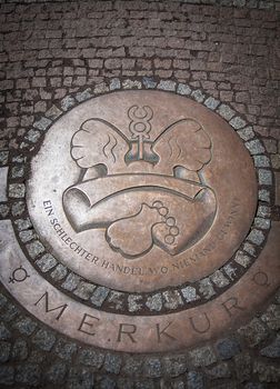 Round Iron hatch for sewer on cobblestone pavement in Dresden, Germany. Steel sewer manhole on pavement.