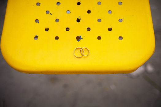 Two wedding rings on a yellow background