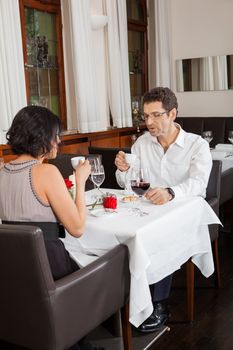 young smiling couple at the restaurant for dinner 