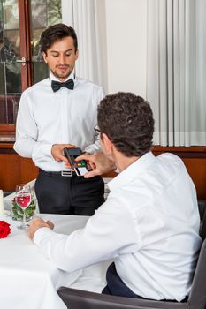 Waiter happily accommodating couple with a big smile on his face