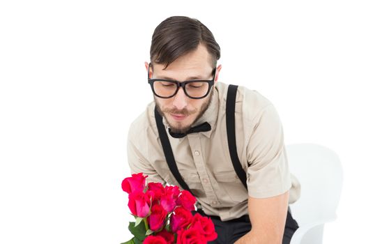 Geeky heartbroken hipster holding roses on white background