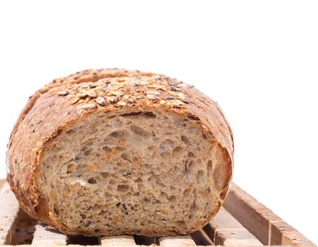 Cut Whole Grain Bread on Wooden Cutting Board over white background