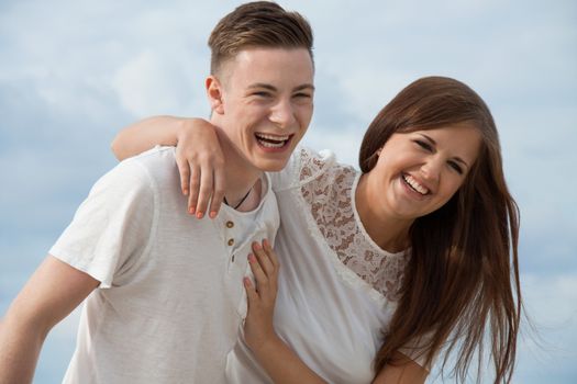 smiling young couple having fun in summer on the beach