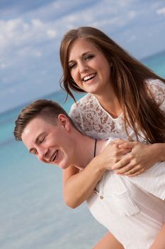 smiling young couple having fun in summer on the beach