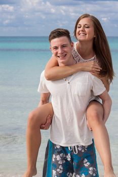 smiling young couple having fun in summer on the beach