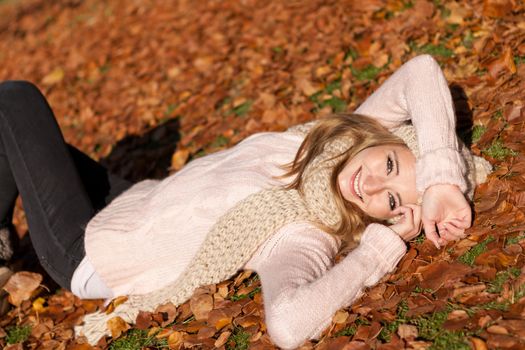 young smiling woman with hat and scarf outdoor in autumn nature background