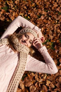 young smiling woman with hat and scarf outdoor in autumn nature background