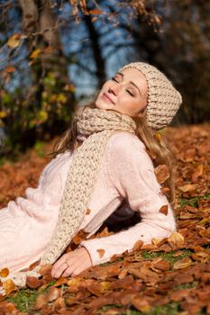 young smiling woman with hat and scarf outdoor in autumn nature background