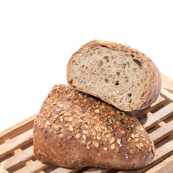 Fresh whole grain bread on cutting board cut in half over white background 