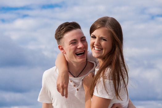 smiling young couple having fun in summer on the beach